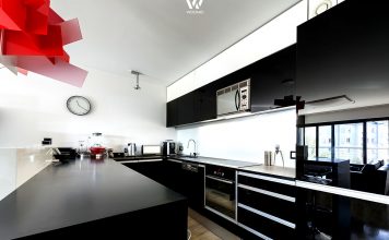 Schwarze Küchen sehen wir immer wieder – wichtig sind aber auch solche Farbklekse wie die rote Lampe hier