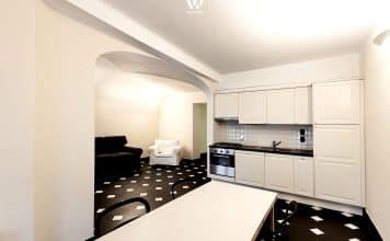 Der Boden im Karomuster ergänzt die dezente Küche ideal und passt zur Architektur der Wohnung