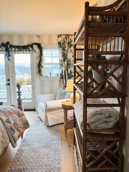 coastal-cottage-bedroom-striped-walls-rattan-bookshelf-the-inspired-room-450x600